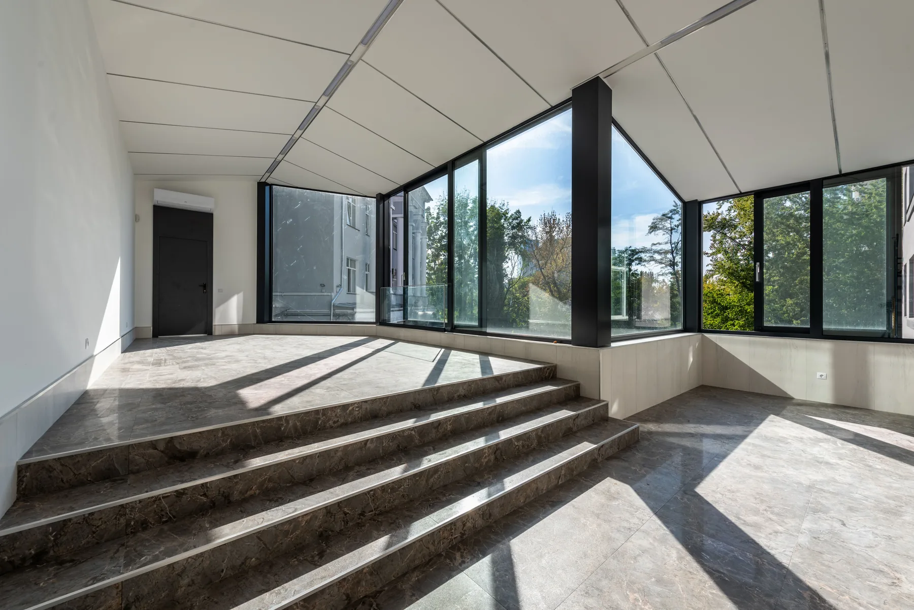 Großzügige moderne Fensterfront in einem hellen Wohnraum nach Sanierung