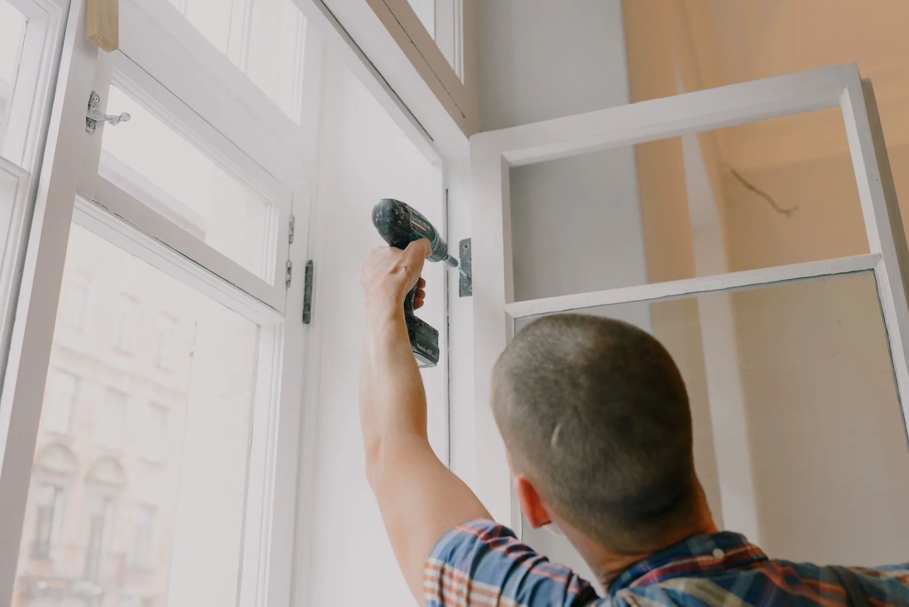 Karriere als Fenster- und Sonnenschutztechniker bei Müller Erfahrener Techniker bei der Fenstermontage im Rahmen einer Sanierung