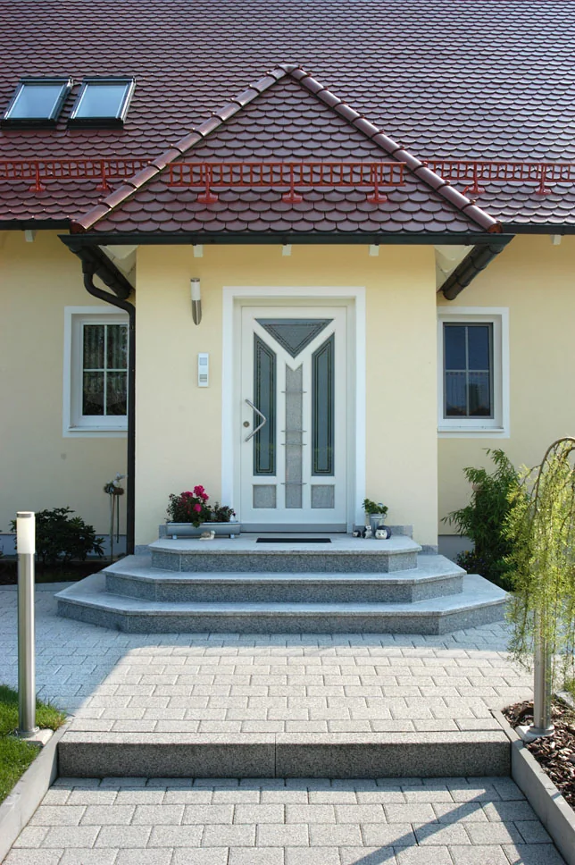 Weiße Haustür bei der Modernisierung Weiße Haustür unter einem Vordach an einem Einfamilienhaus